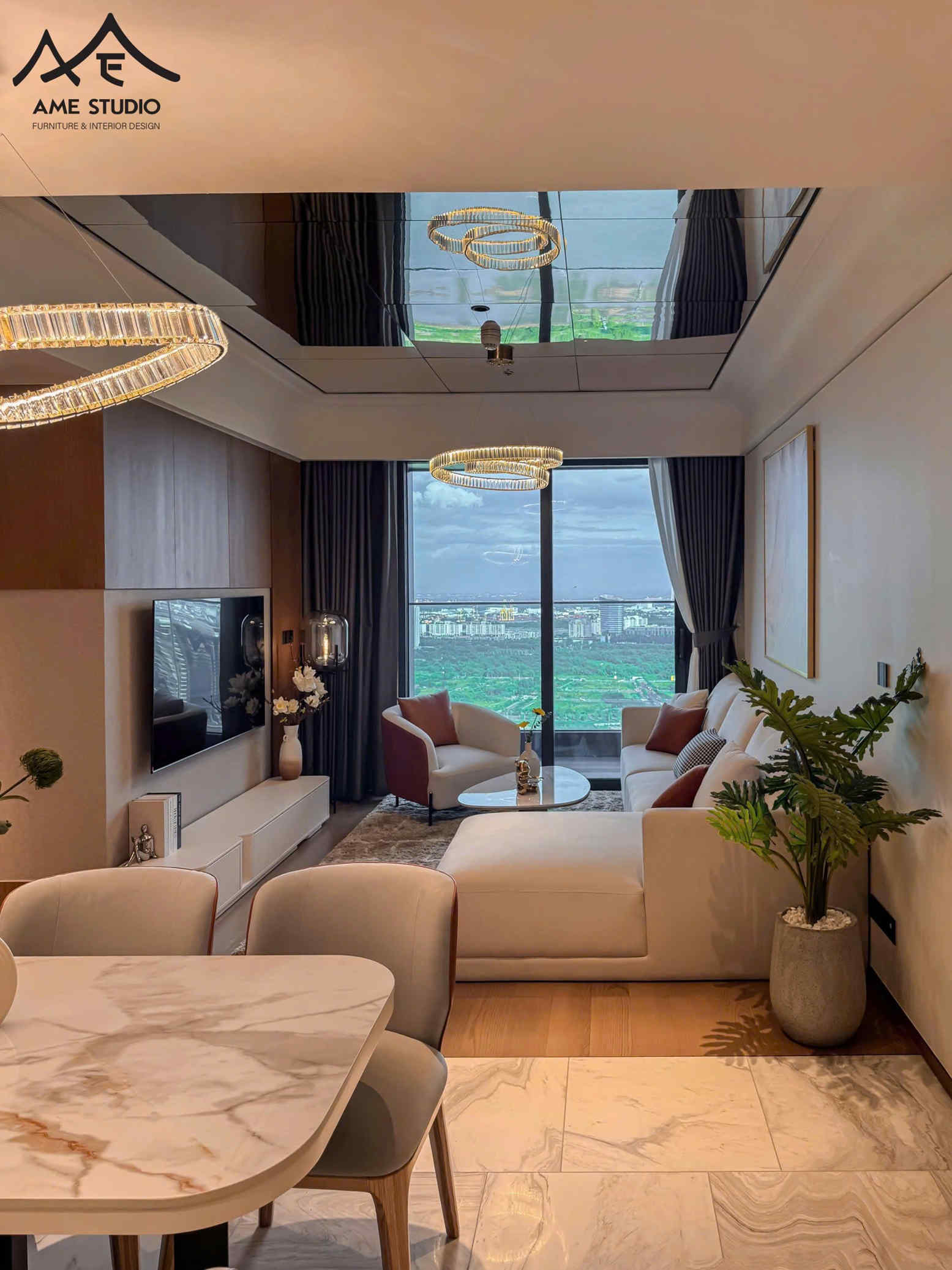 Phòng khách chung cư hiện đại với sofa chữ L màu kem, bàn trà tròn, đèn trần vòng LED và bàn ăn mặt đá marble