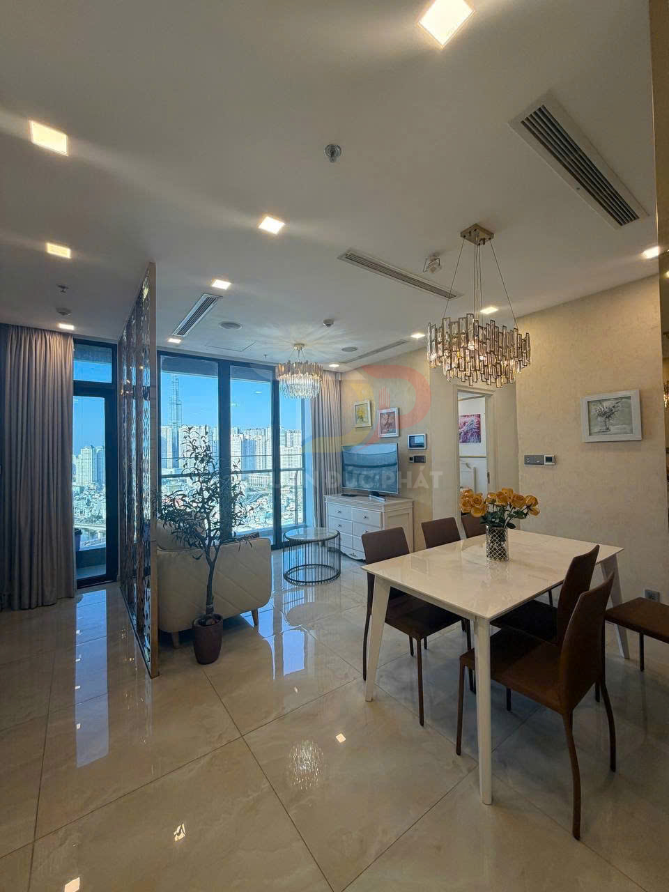 Phòng ăn chung cư hiện đại với bàn ăn mặt đá trắng, ghế da nâu và cửa kính lớn view thành phố