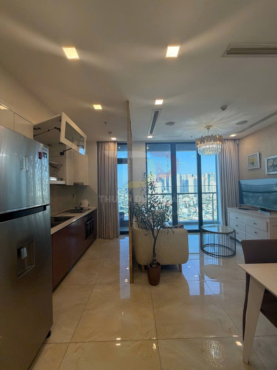 Căn hộ chung cư hiện đại với bếp liền phòng khách, nội thất sáng màu và cửa kính lớn nhìn ra thành phố
