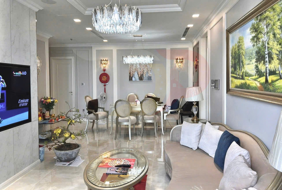 Phòng khách căn hộ cao cấp với sofa, bàn kính, đèn chùm pha lê và bàn ăn sang trọng