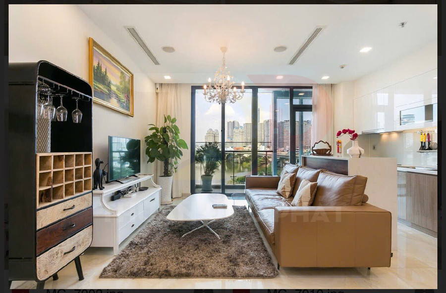 Phòng khách căn hộ hiện đại với sofa da nâu, bàn trà trắng, kệ tivi và cửa kính lớn nhìn ra thành phố