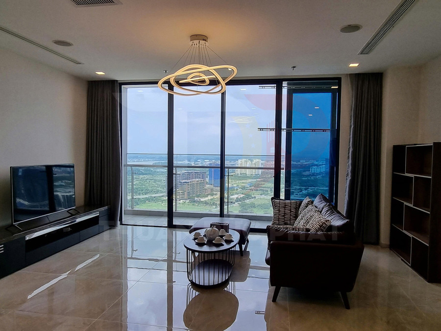 Phòng khách căn hộ hiện đại với sofa da, bàn trà và tivi lớn nhìn ra cửa kính toàn cảnh thành phố