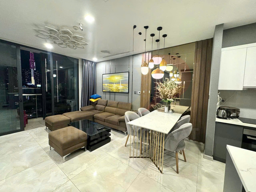 Phòng khách căn hộ hiện đại với sofa chữ L, bàn trà đen, bàn ăn đá marble và đèn thả trang trí sang trọng