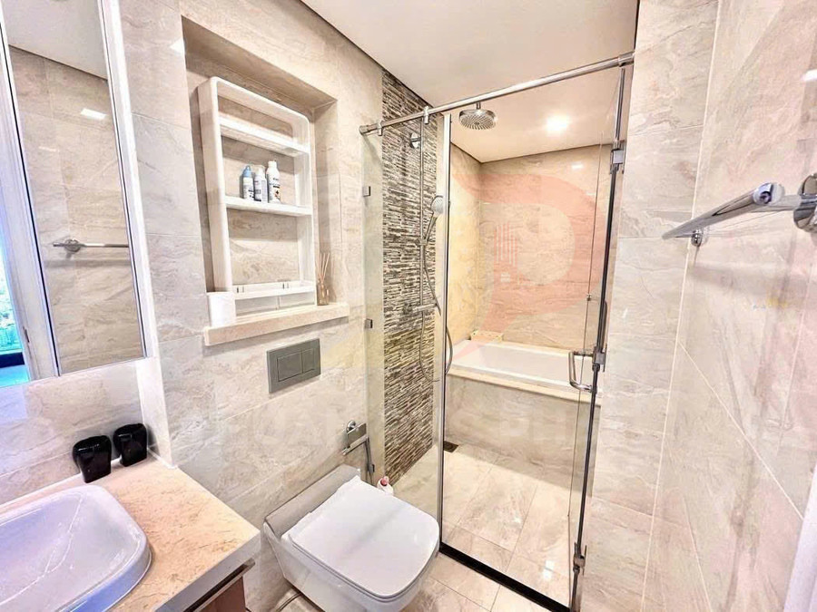 Phòng tắm hiện đại với bồn tắm kính, vòi sen treo tường, bồn cầu treo và kệ đựng đồ gắn tường