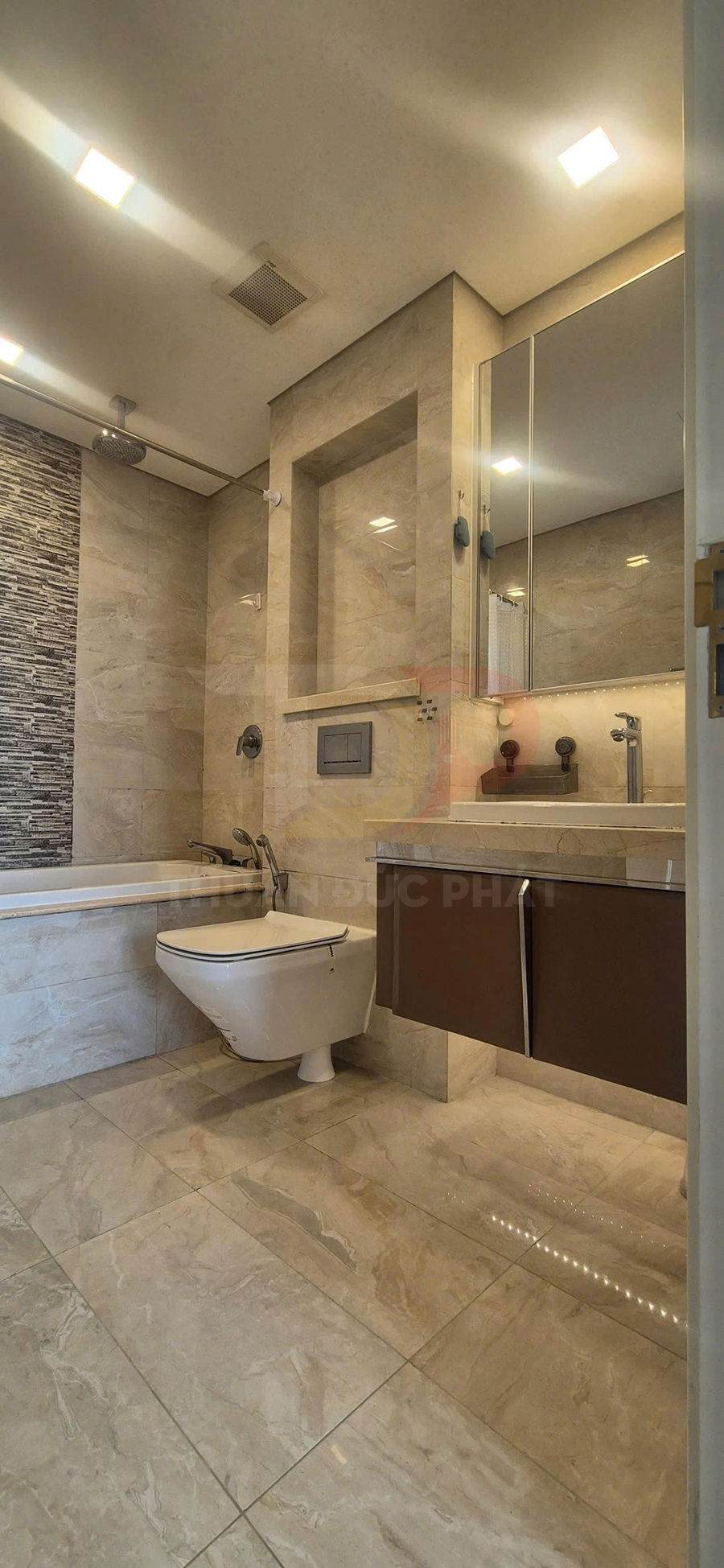 Phòng tắm hiện đại với bồn tắm, bồn cầu treo tường, lavabo đá và tủ gỗ màu nâu