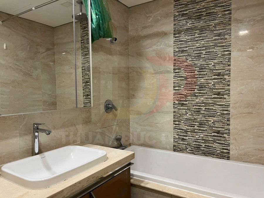 Phòng tắm hiện đại với bồn tắm nằm, lavabo đá và vòi sen treo tường, ốp gạch vân đá sang trọng
