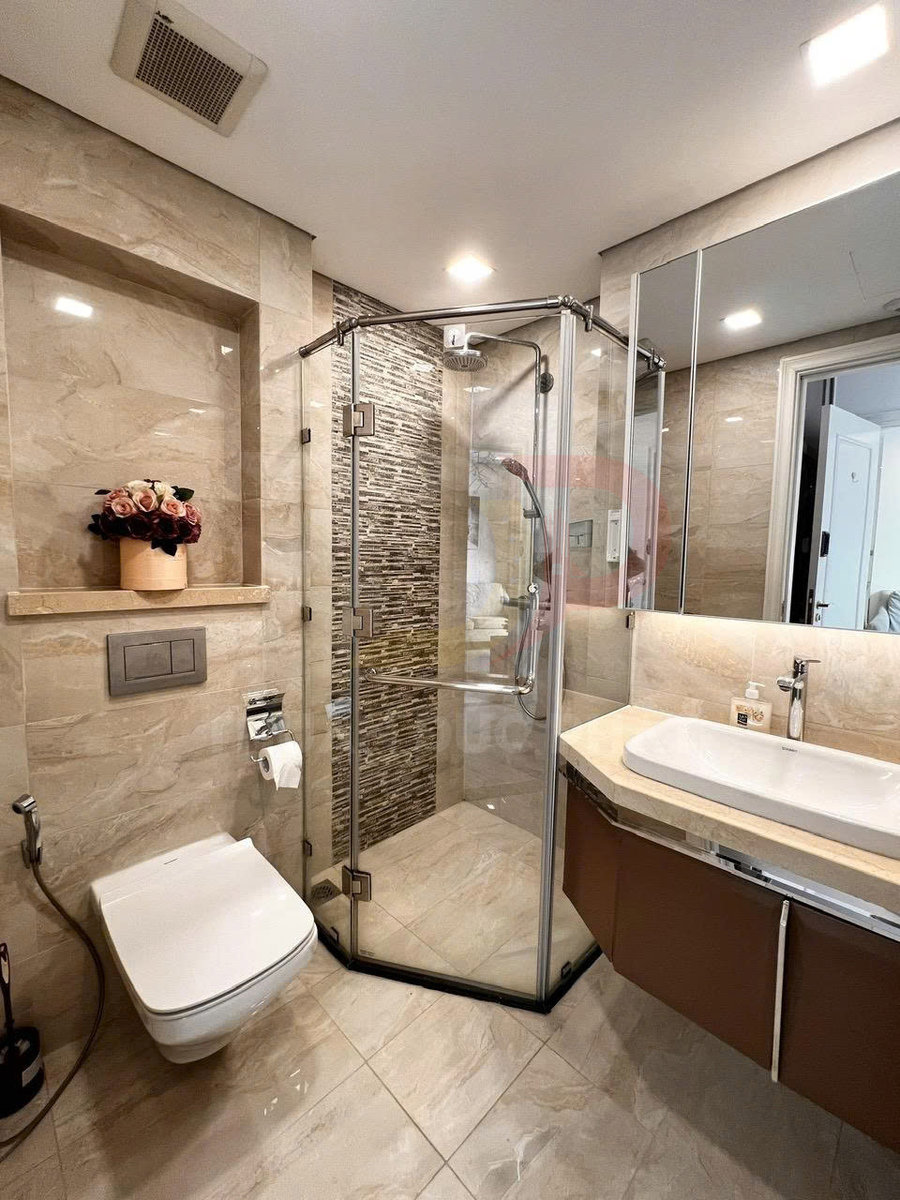 Phòng tắm hiện đại với buồng tắm kính góc, bồn cầu treo tường và lavabo đá sang trọng