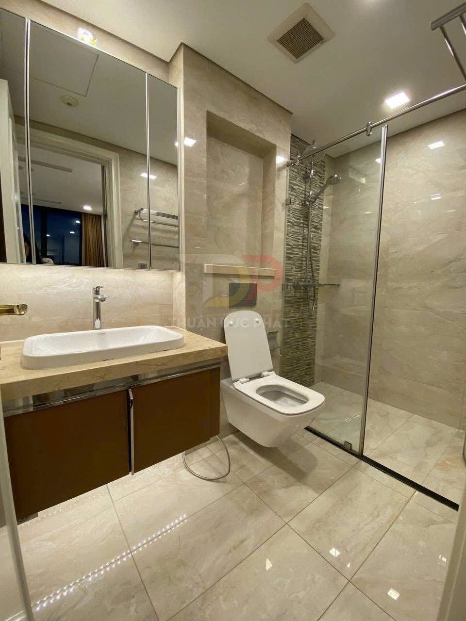 Phòng tắm hiện đại với bồn cầu treo tường, lavabo đặt bàn và buồng tắm kính sang trọng
