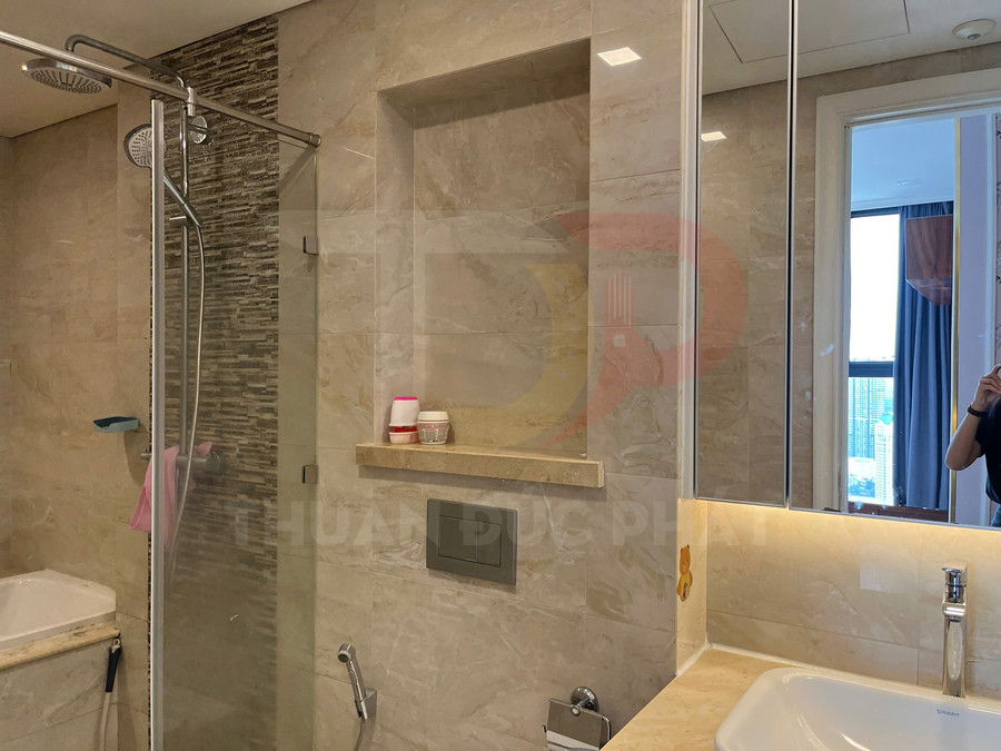 Phòng tắm hiện đại với vách kính tắm đứng, vòi sen inox và bồn rửa mặt cạnh gương lớn