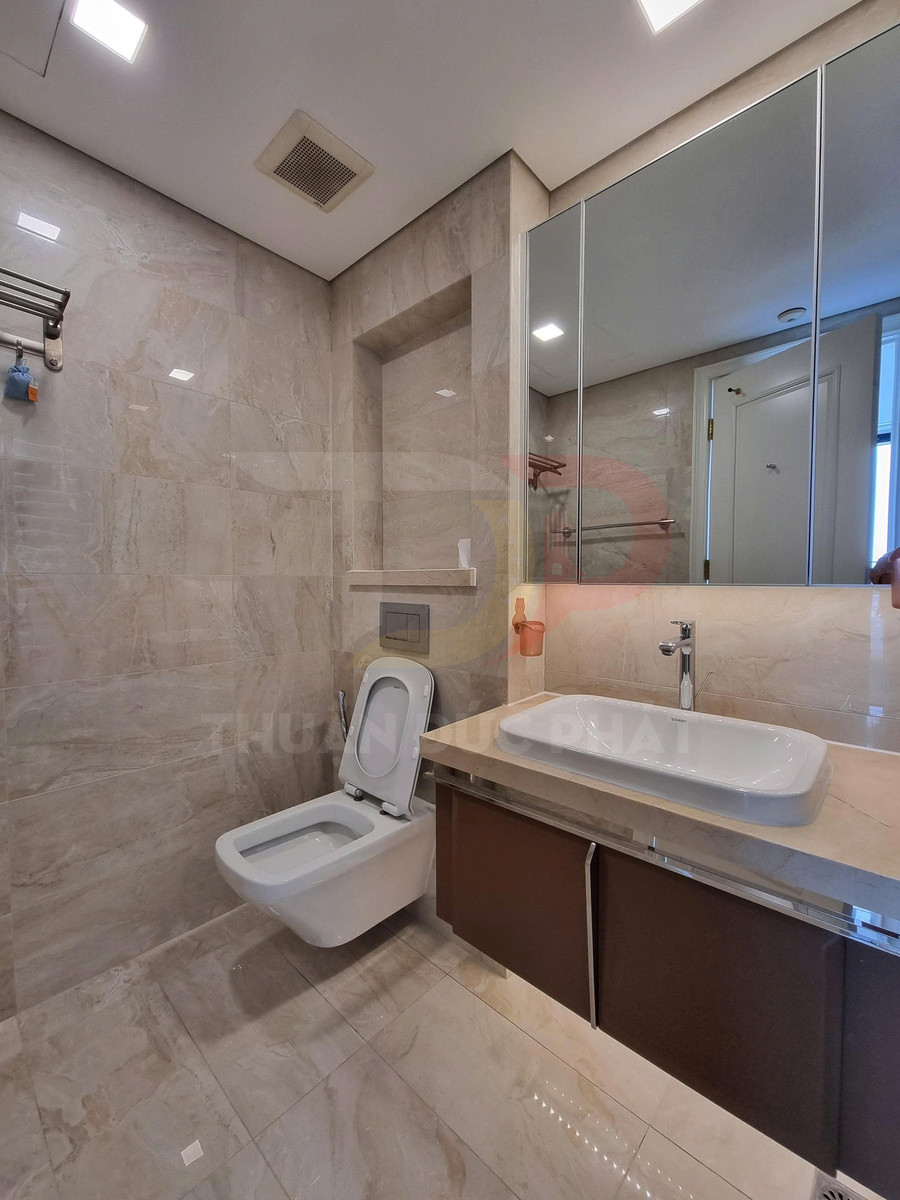 Phòng tắm hiện đại với bồn cầu treo tường, lavabo đặt bàn và tủ gương lớn ốp đá marble
