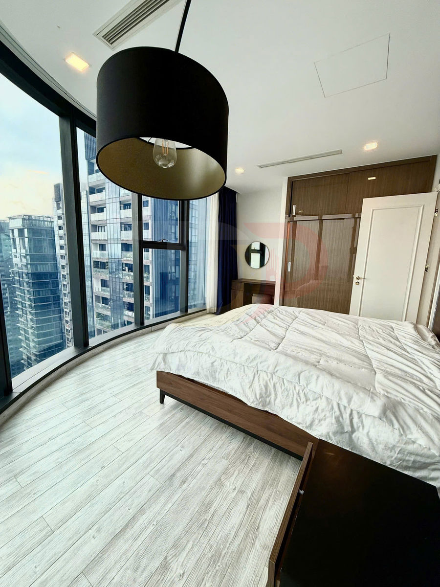 Phòng ngủ chung cư hiện đại với giường gỗ, chăn trắng, cửa kính lớn và đèn trần đen kiểu dáng đơn giản