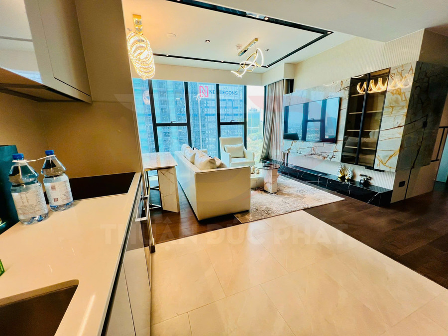 Phòng khách căn hộ hiện đại với sofa trắng, tivi treo tường và cửa kính lớn nhìn ra thành phố
