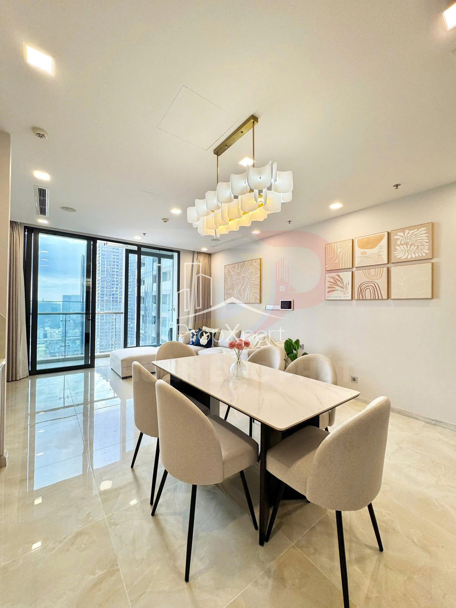 Bàn ăn mặt đá với sáu ghế bọc nỉ màu be trong phòng khách chung cư hiện đại nhiều ánh sáng