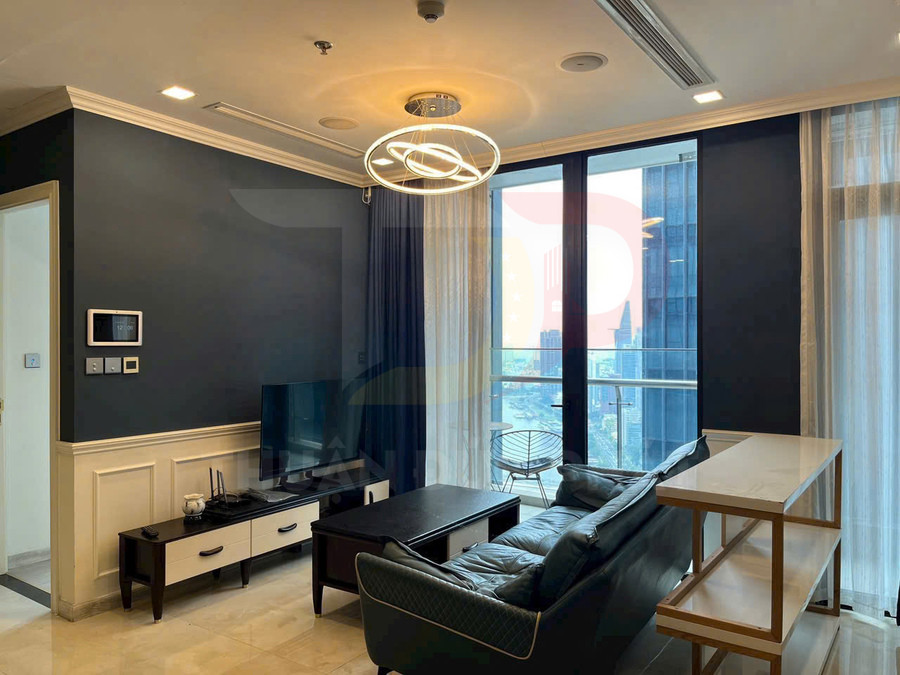 Phòng khách căn hộ hiện đại với sofa da, kệ tivi, đèn trần trang trí và cửa kính lớn nhìn ra ban công