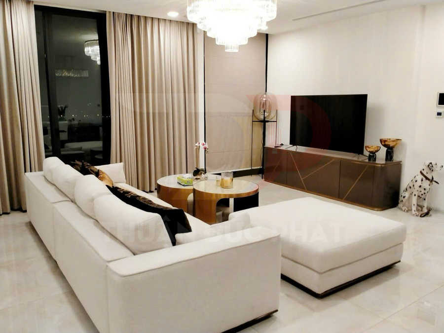 Sofa góc bọc nỉ màu trắng trong phòng khách hiện đại với bàn trà tròn và kệ tivi gỗ sang trọng
