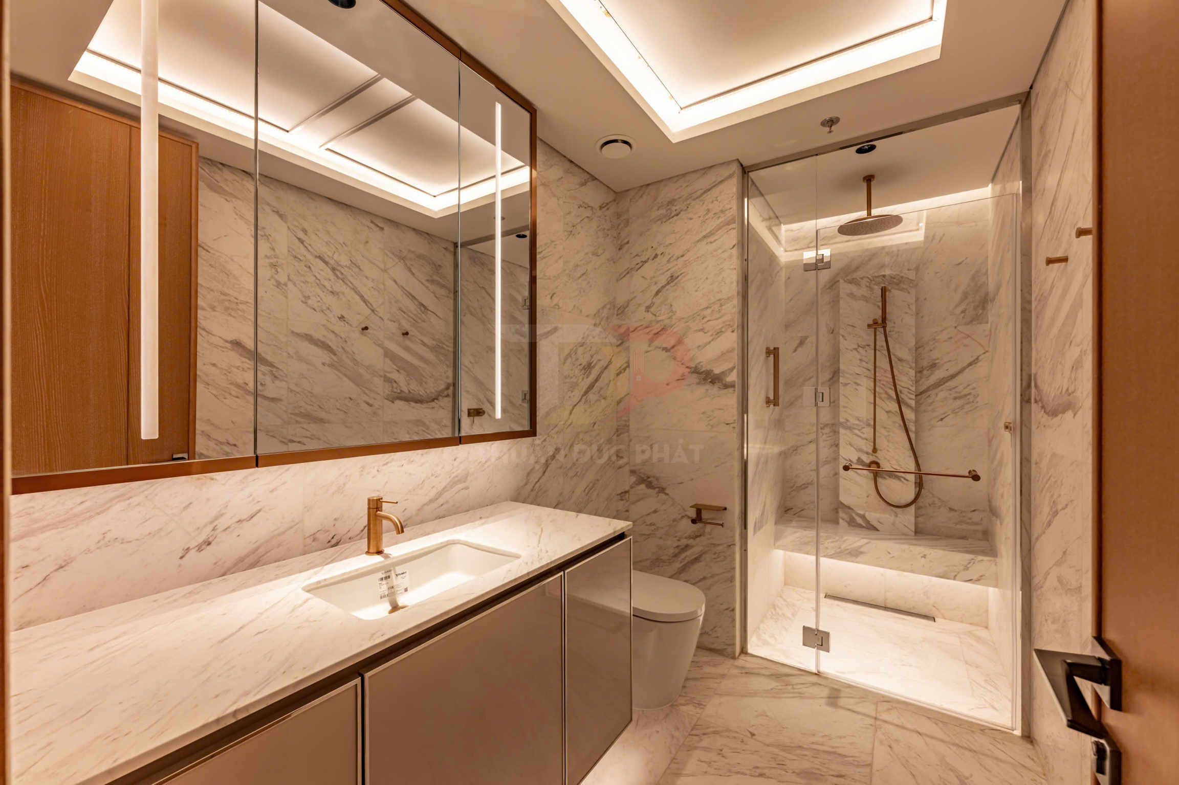 Phòng tắm đá marble cao cấp với tủ lavabo, vòi nước vàng đồng và buồng tắm kính hiện đại