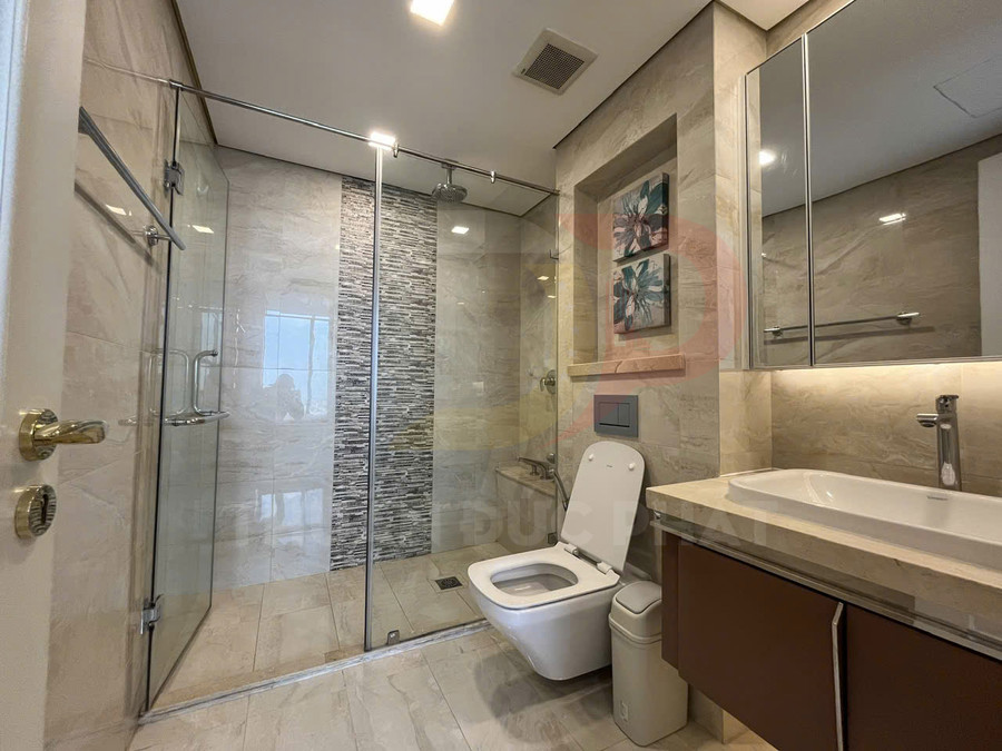 Phòng tắm hiện đại với buồng tắm kính, bồn cầu treo tường và lavabo mặt đá sáng màu