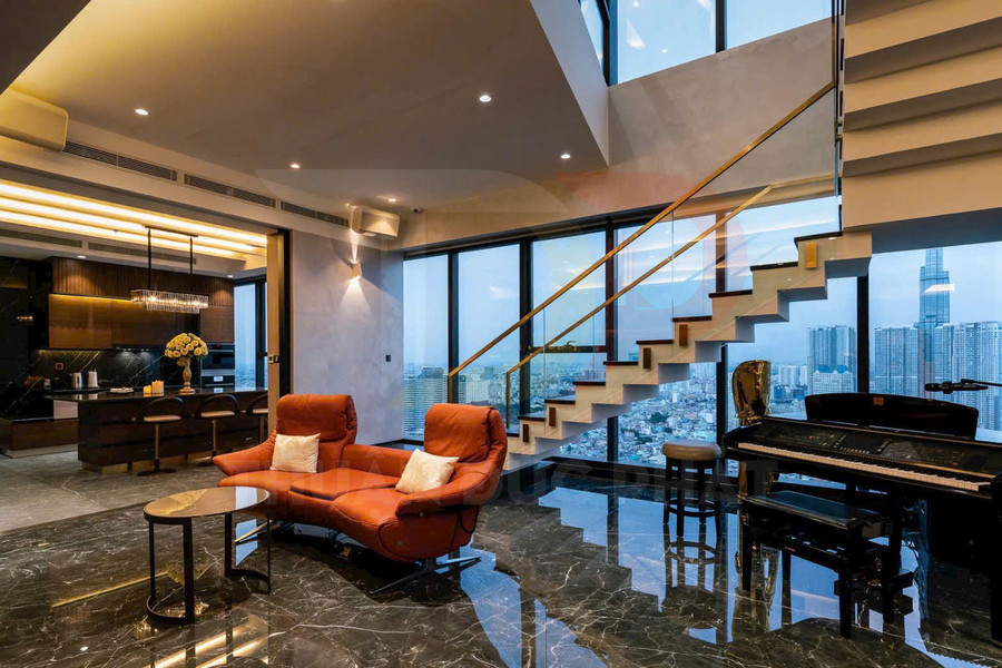 Phòng khách căn hộ cao cấp với ghế sofa da cam, bàn trà tròn, cầu thang kính và đàn piano cạnh cửa sổ lớn