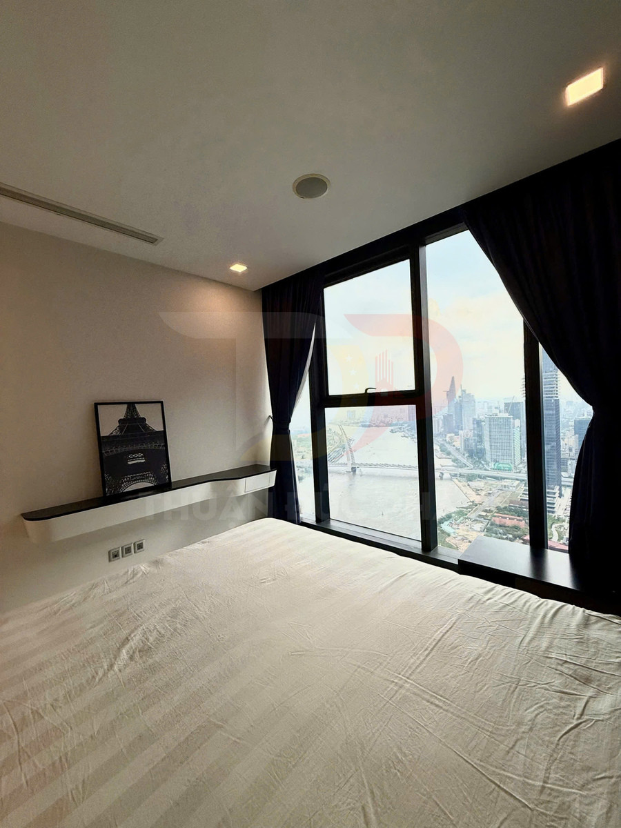 Phòng ngủ tối giản với giường lớn cạnh cửa sổ kính toàn cảnh nhìn ra thành phố
