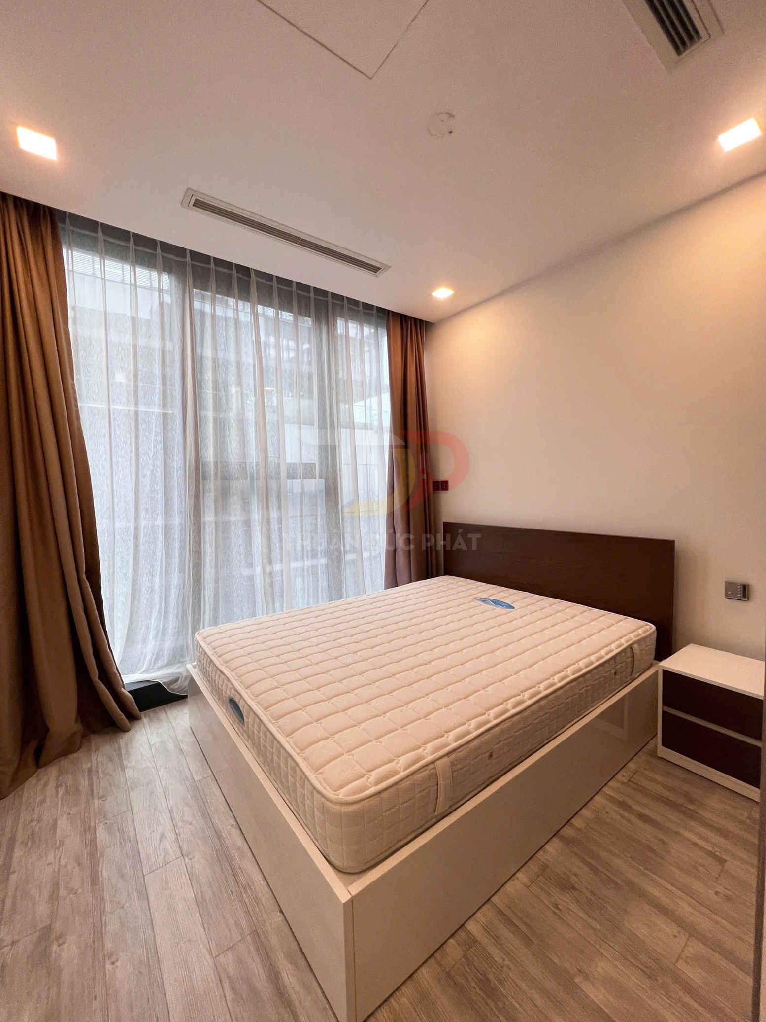 Giường ngủ gỗ hiện đại với nệm dày màu kem trong phòng ngủ sáng có rèm cửa lớn