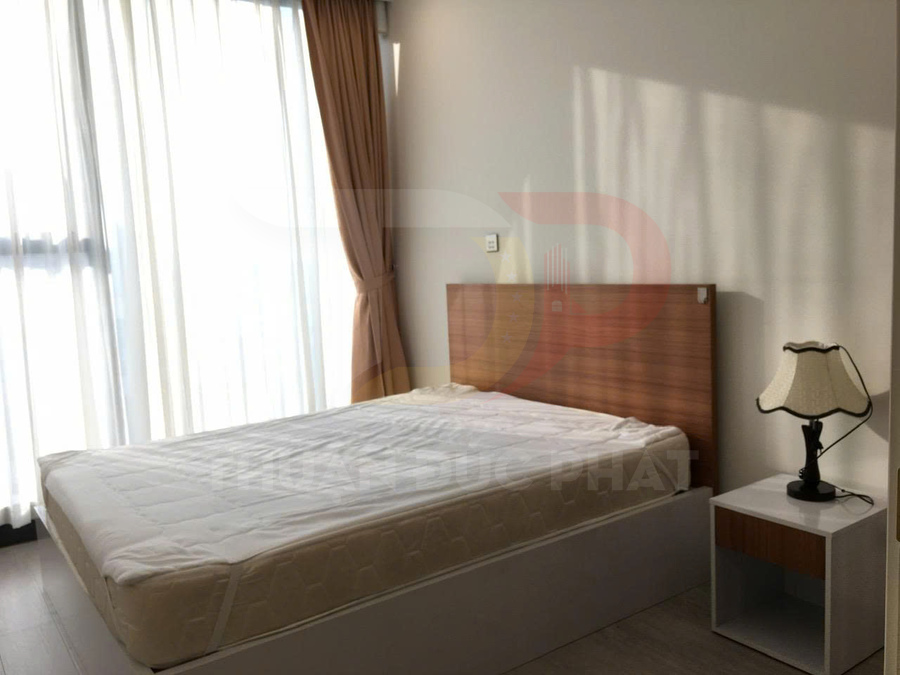 Giường ngủ gỗ hiện đại với nệm trắng cạnh cửa sổ lớn và bàn đầu giường có đèn ngủ