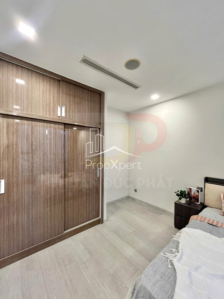 Tủ quần áo gỗ cửa lùa hiện đại trong phòng ngủ sáng màu, cạnh giường và tủ đầu giường nhỏ