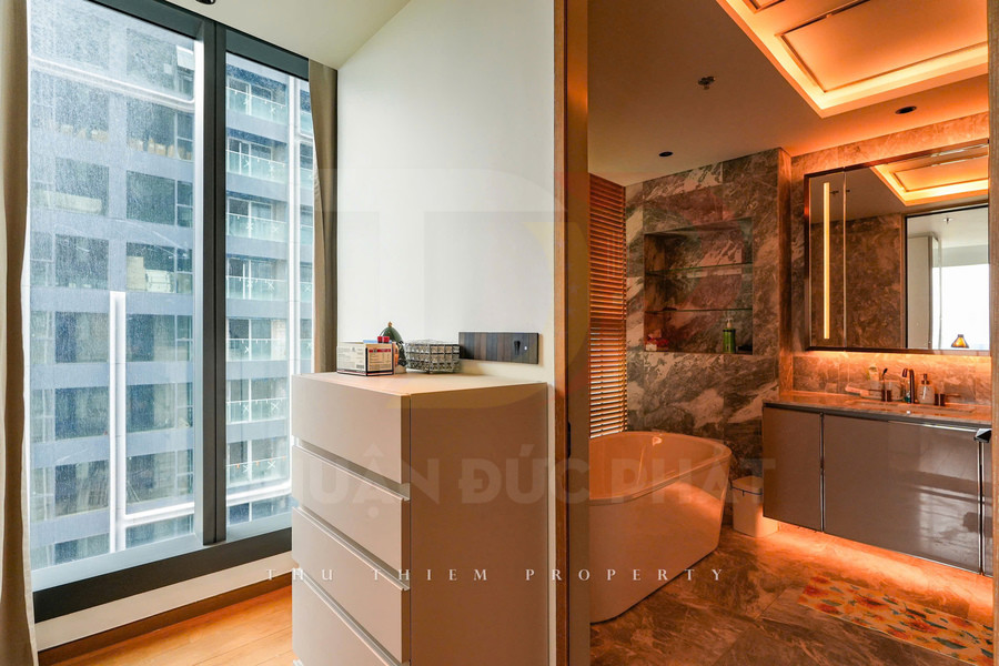 Phòng tắm chung cư cao cấp với bồn tắm đứng độc lập, tủ lavabo hiện đại và cửa sổ kính lớn nhìn ra thành phố