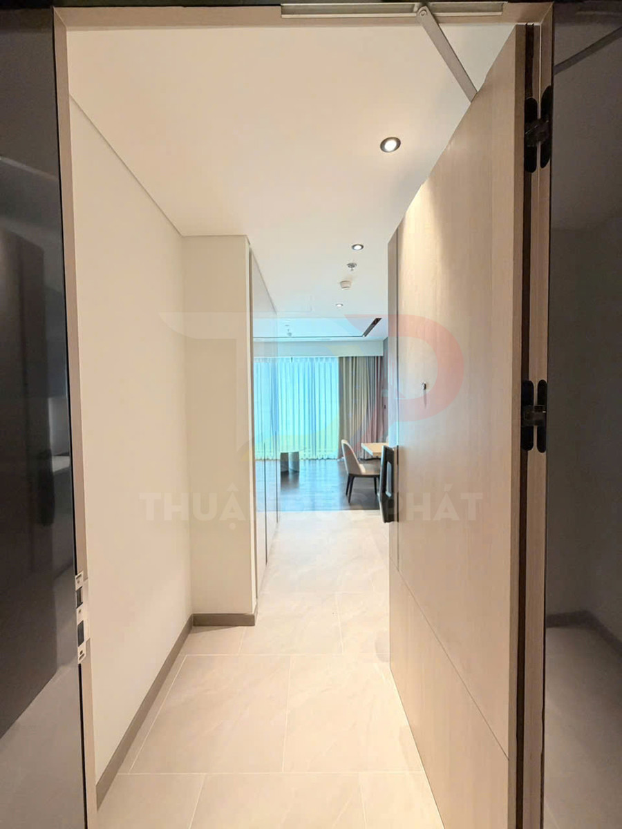 Cửa gỗ chống cháy mở vào hành lang căn hộ hiện đại, sàn gạch sáng và phòng khách phía cuối hành lang