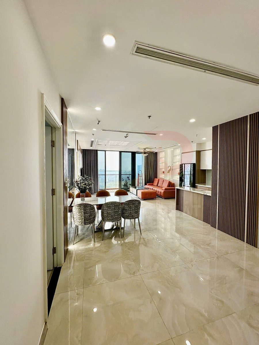 Phòng khách chung cư hiện đại với bộ bàn ăn, ghế bọc nệm và sofa da màu cam cạnh cửa kính lớn
