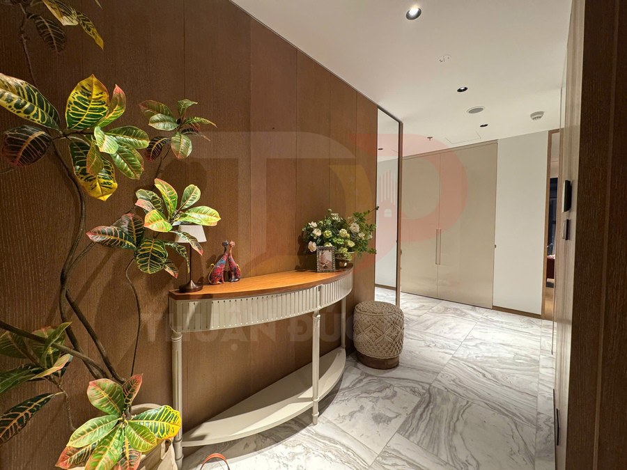 Bàn console gỗ trang trí bình hoa và đồ decor trong hành lang căn hộ lát đá marble