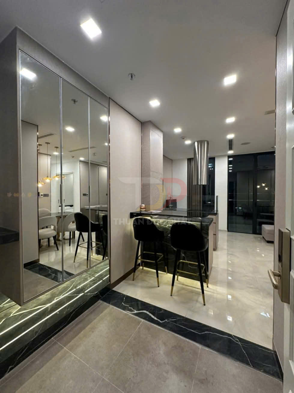 Nội thất căn hộ hiện đại với tủ gương lớn, quầy bar đá và ghế cao màu đen sang trọng