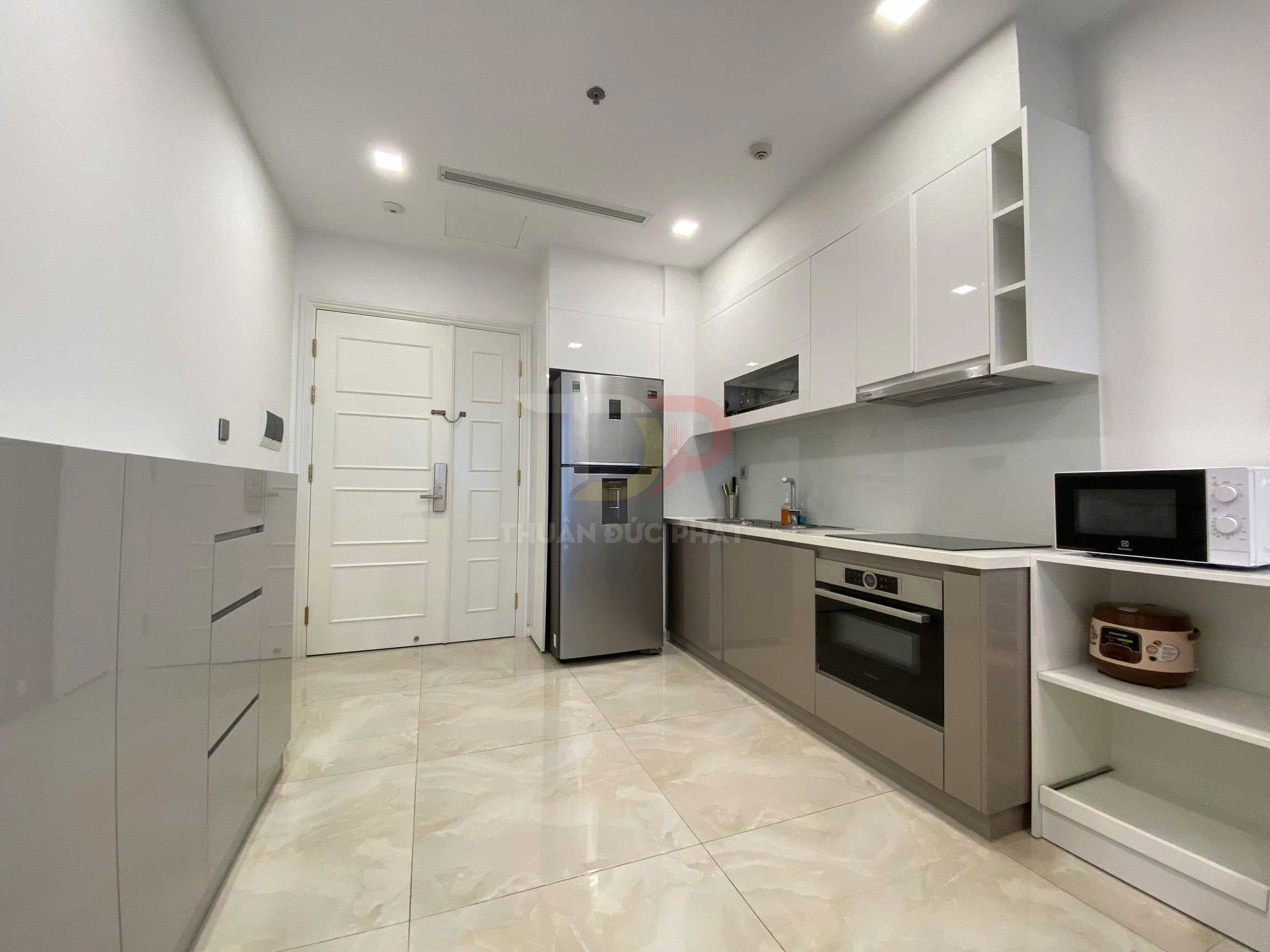 Bếp hiện đại với tủ bếp chữ I, tủ lạnh inox, lò nướng âm tủ, bếp từ và lò vi sóng Electrolux