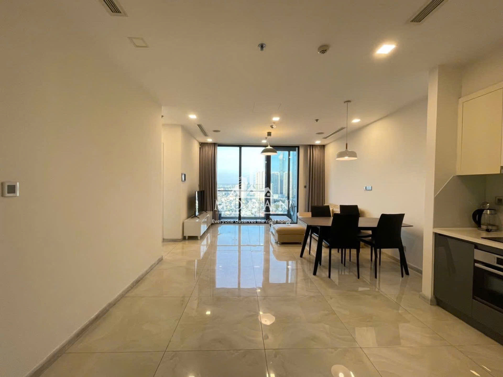 Căn hộ chung cư hiện đại với phòng khách, bàn ăn, bếp mở và cửa kính lớn nhìn ra thành phố