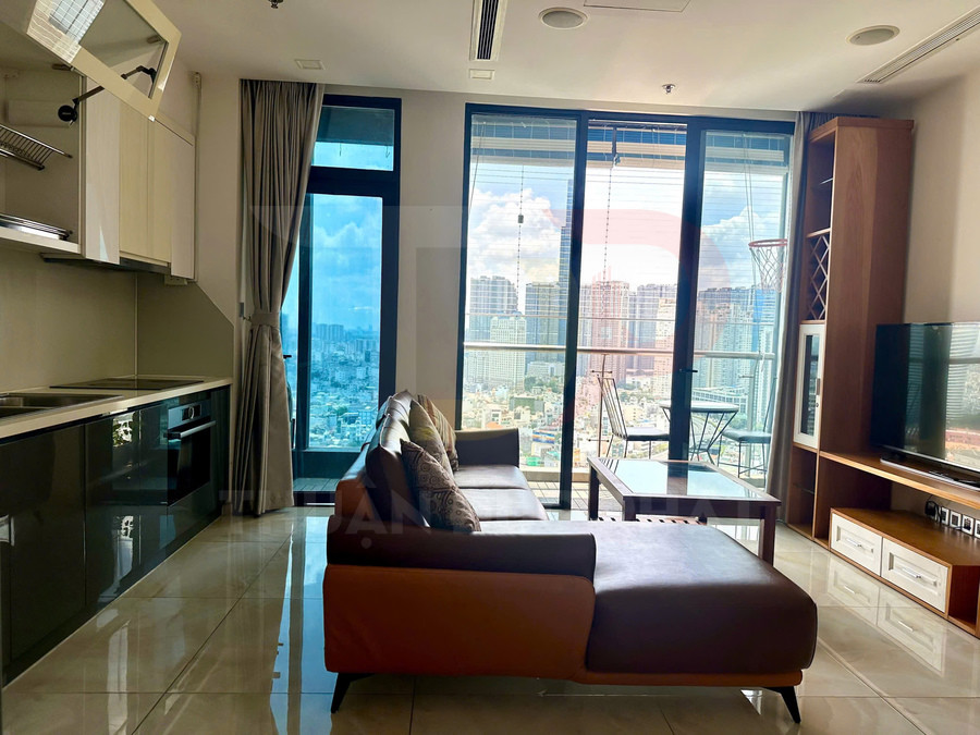 Phòng khách căn hộ hiện đại với sofa da, bếp liền kề và cửa kính lớn nhìn ra thành phố