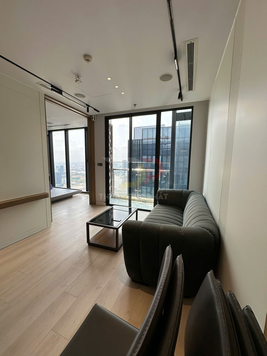 Sofa da màu đen và bàn kính trong phòng khách chung cư hiện đại với cửa kính lớn nhìn ra thành phố