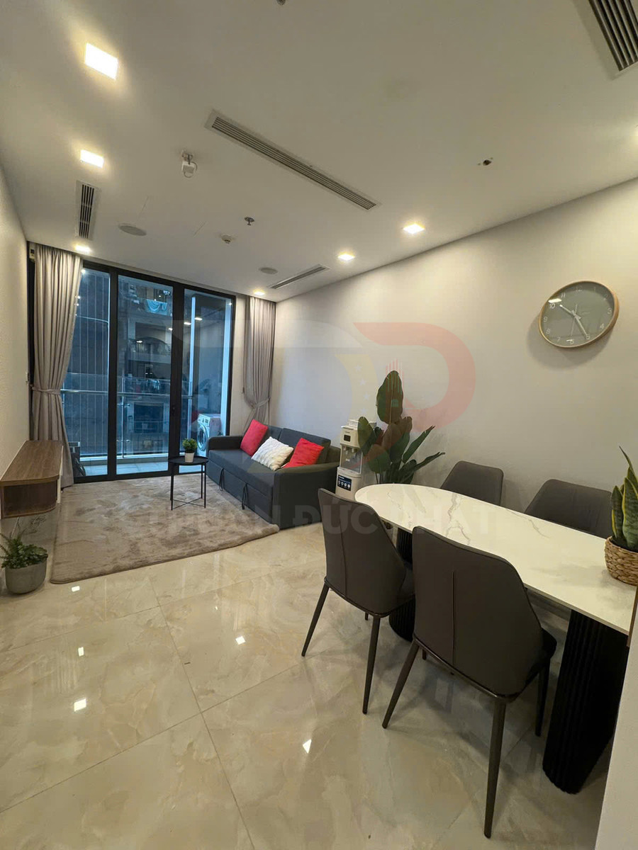 Phòng khách chung cư hiện đại với sofa xám, bàn ăn mặt đá và sàn gạch bóng sáng