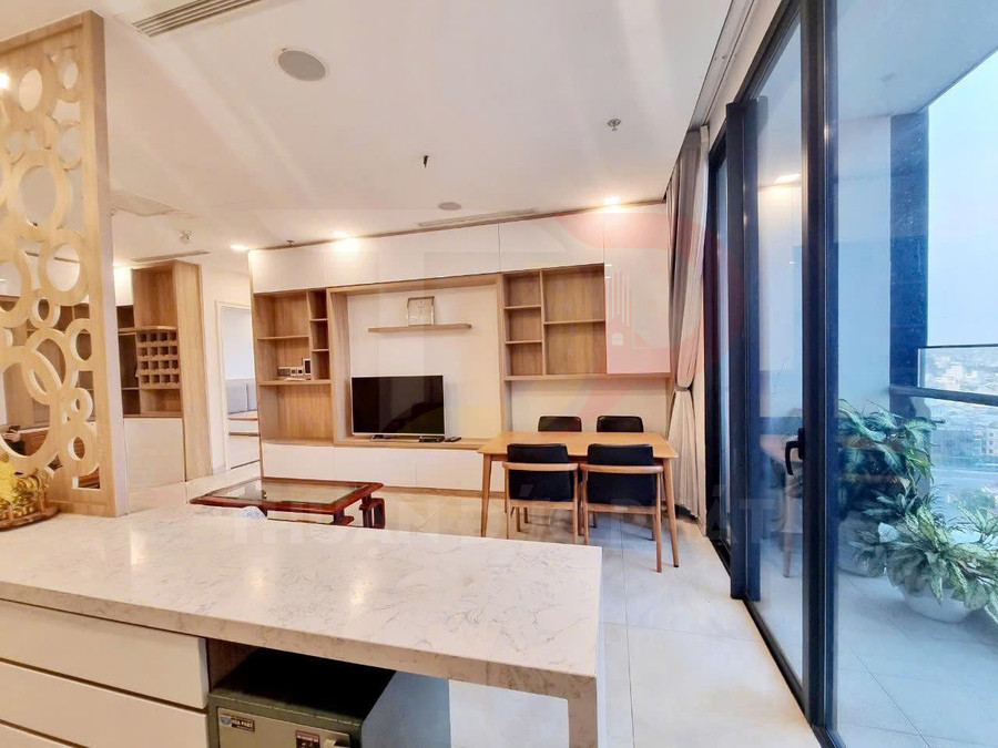 Phòng khách chung cư hiện đại với kệ tivi gỗ, bàn ăn bốn ghế và cửa kính lớn nhìn ra ban công