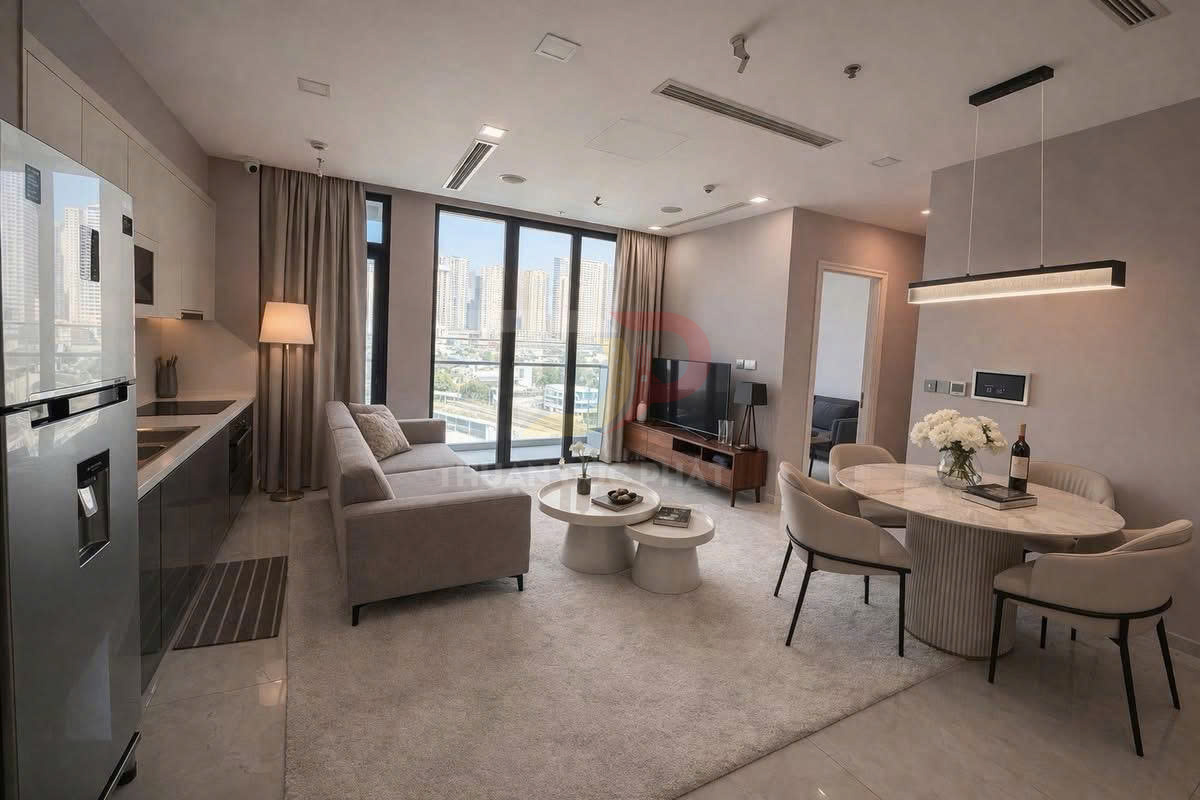 Phòng khách căn hộ hiện đại với sofa xám, bàn trà tròn, bếp liền kề và bàn ăn tròn cạnh cửa sổ lớn