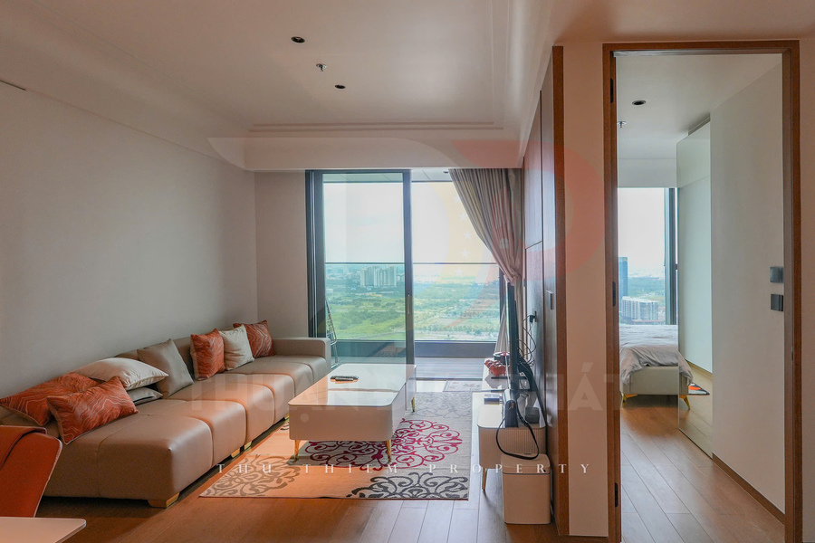Phòng khách căn hộ hiện đại với sofa chữ L, bàn trà trắng và cửa kính lớn nhìn ra thành phố