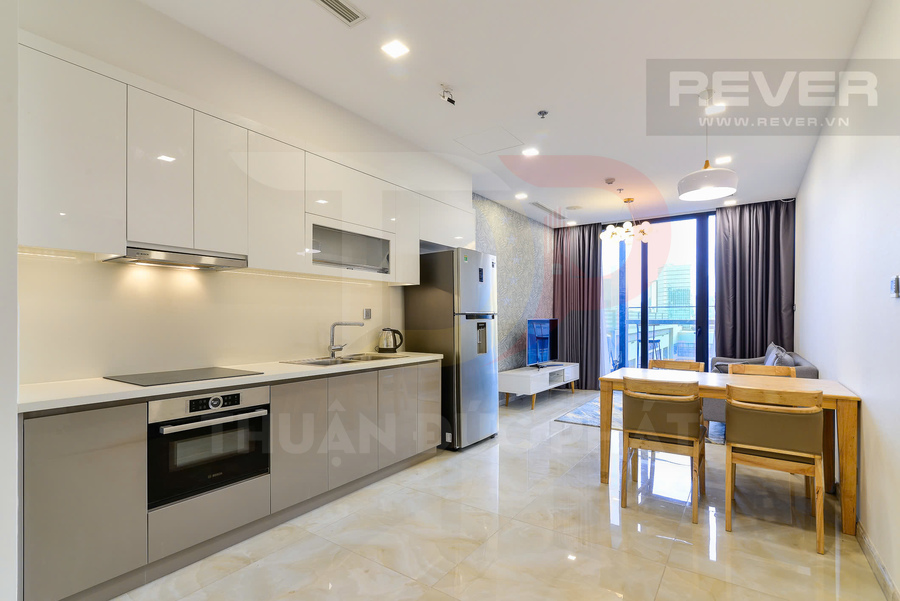 Căn hộ chung cư hiện đại với bếp liền phòng khách, bàn ăn gỗ và cửa kính lớn nhìn ra ban công