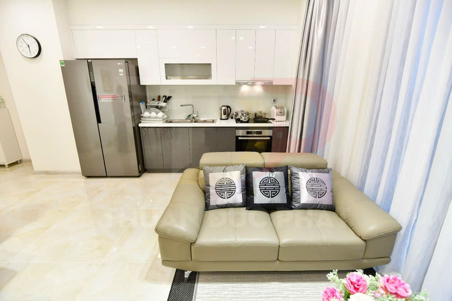 Sofa da màu be với gối trang trí trước bếp hiện đại và tủ lạnh LG trong căn hộ sáng sủa