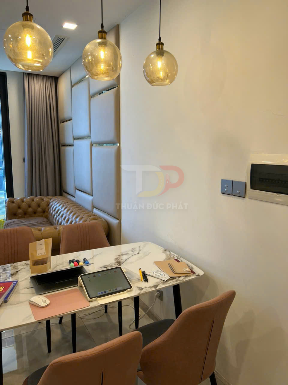 Bàn làm việc với iPad trên giá đỡ, chuột không dây và sổ tay trong phòng khách hiện đại