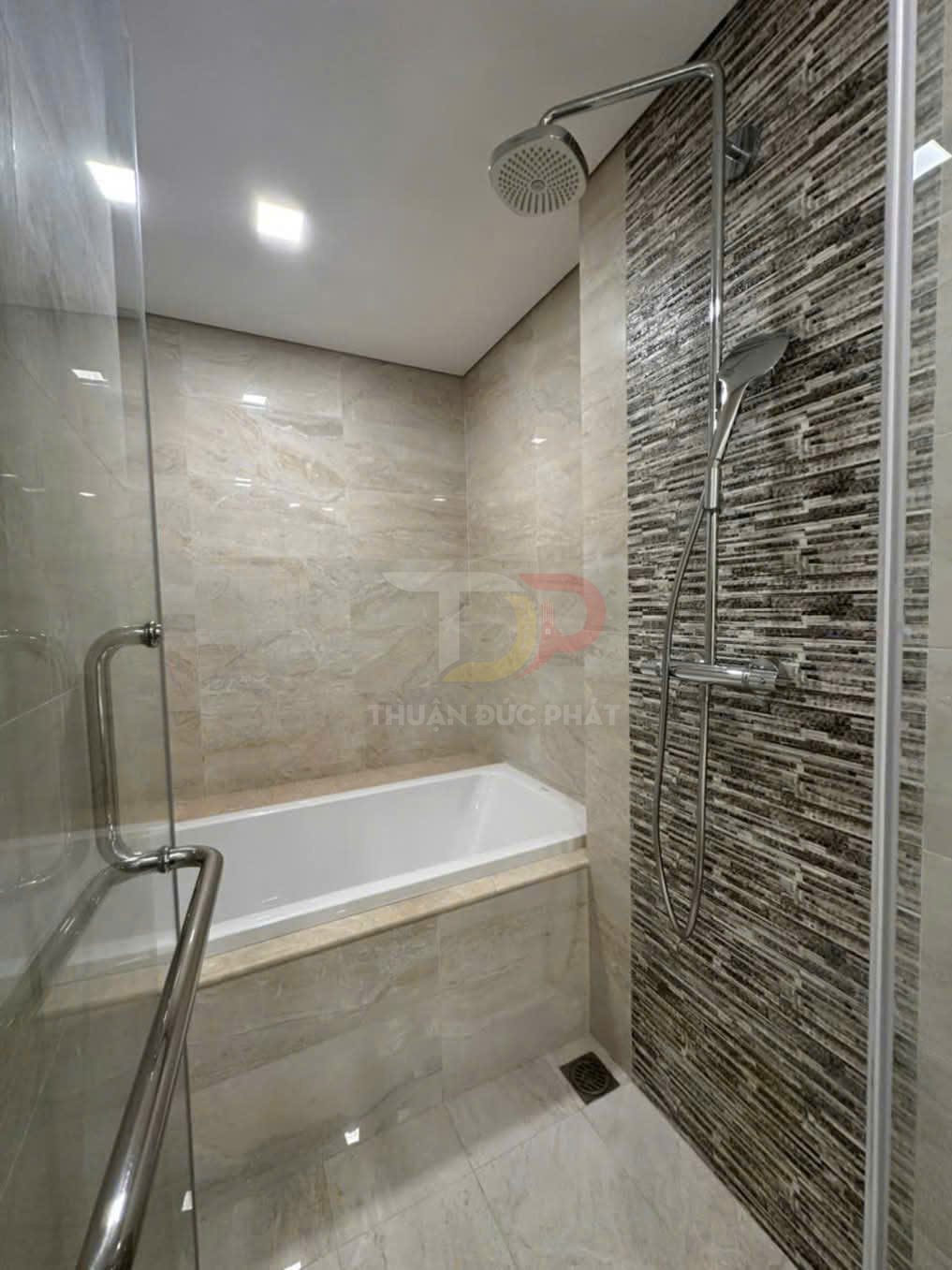 Bồn tắm nằm kèm vòi sen đứng inox trong phòng tắm ốp gạch đá hiện đại