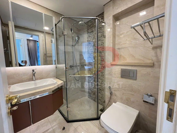 Phòng tắm hiện đại với buồng tắm kính, bồn rửa mặt lớn và bồn cầu treo tường gọn gàng