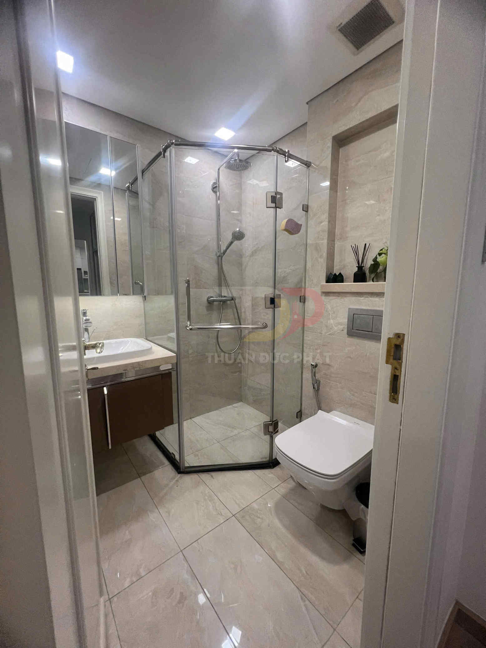 Phòng tắm hiện đại với buồng tắm kính, bồn cầu treo tường và lavabo đá sang trọng