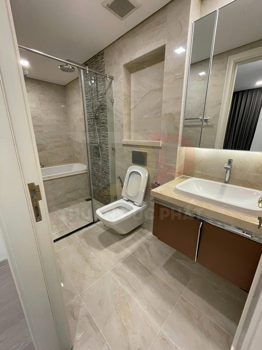 Phòng tắm hiện đại với bồn cầu treo tường, buồng tắm kính và lavabo trên tủ gỗ