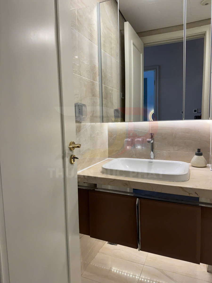 Bồn rửa mặt đặt trên mặt đá marble với tủ lavabo nâu trong phòng tắm hiện đại