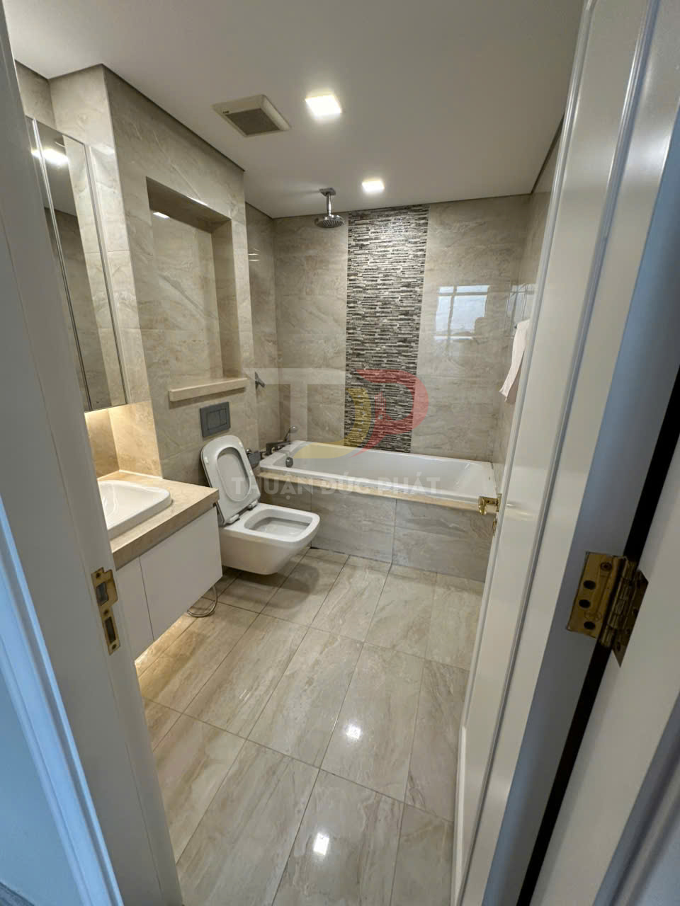 Phòng tắm hiện đại với bồn cầu treo tường, bồn tắm nằm và lavabo đá sang trọng