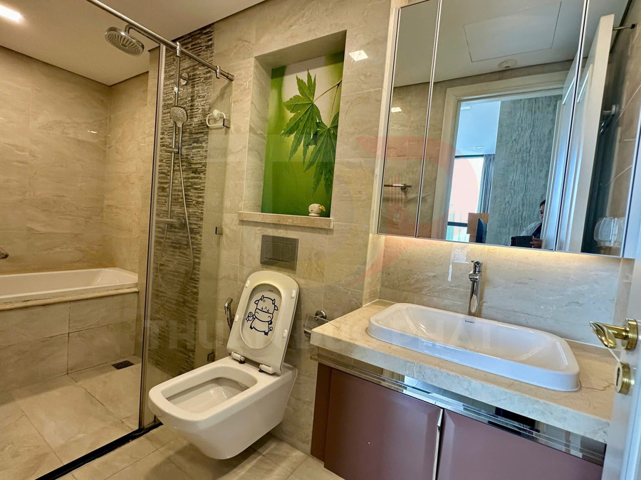 Phòng tắm hiện đại với bồn tắm, buồng tắm kính, bồn cầu có nắp trẻ em và lavabo đá sáng màu