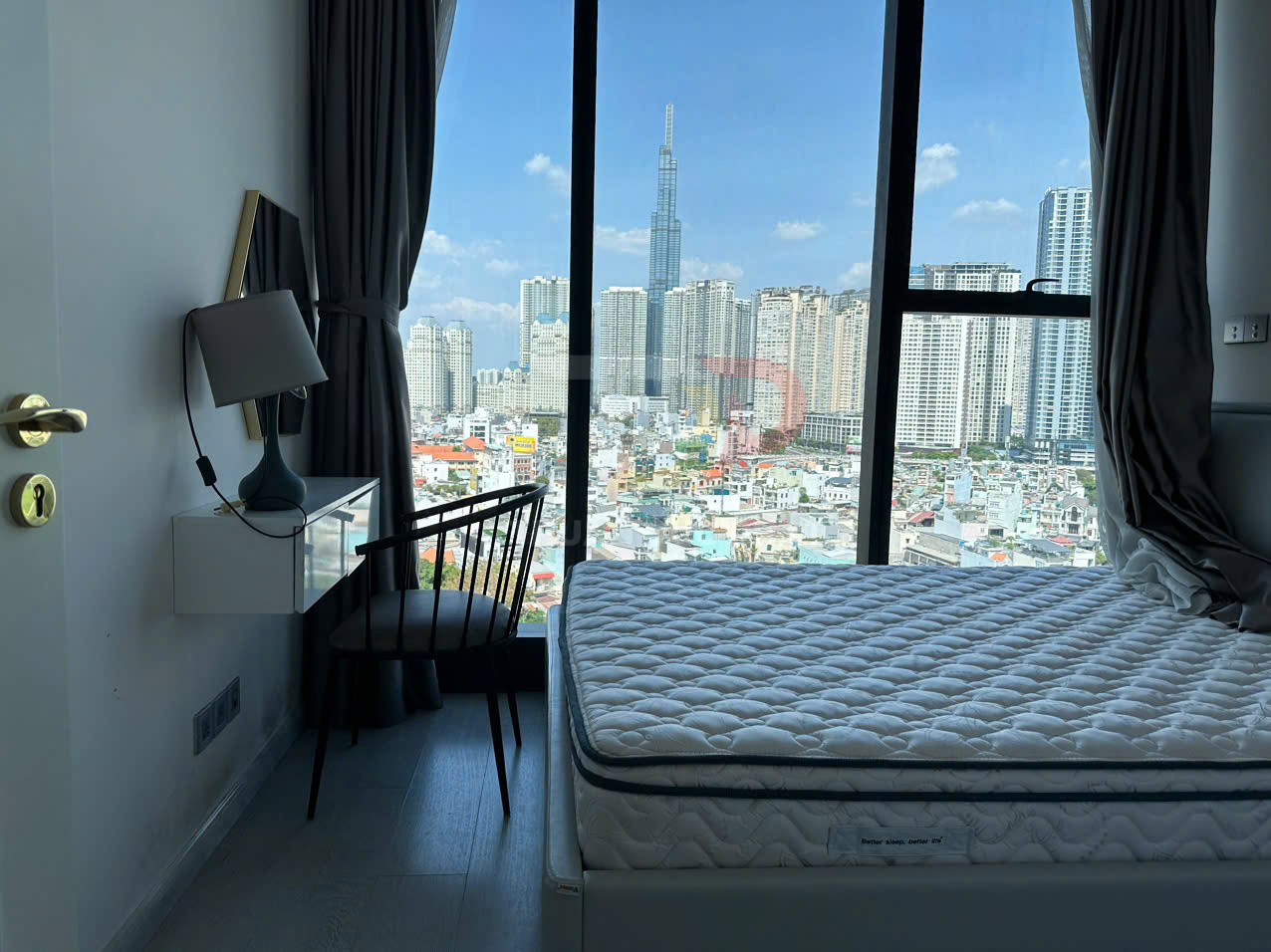 Nệm giường dày trong phòng ngủ chung cư hiện đại với cửa sổ lớn nhìn ra khu đô thị cao tầng